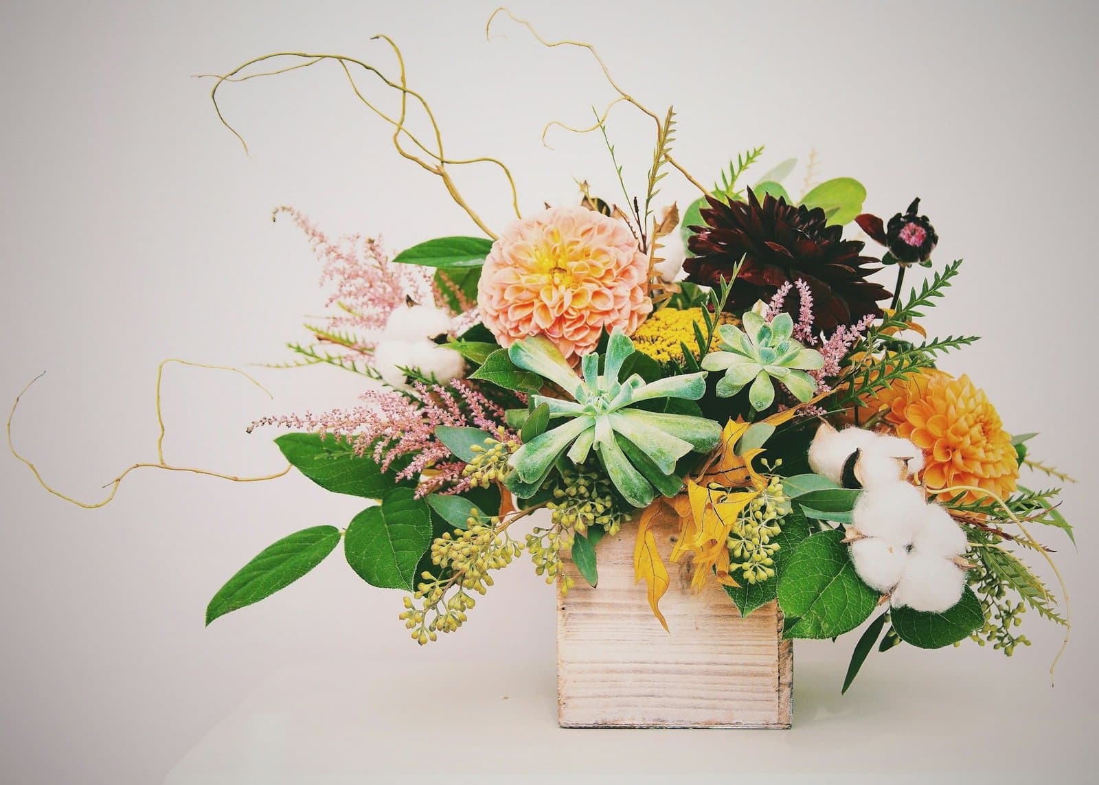 Autumn flower arrangement in warm rust and amber tones, photographed in soft natural daylight